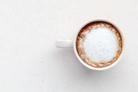 Mug of coffee with milk on a light background. Milk foam.の写真素材
