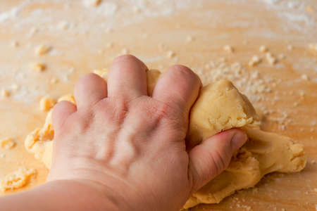 Hand kneading dough. Homemade sweet cake. Family pastries. Tart weekend. Pastries for Christmas. Man and home.の写真素材