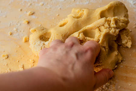 Hand kneading dough. Homemade sweet cake. Family pastries. Tart weekend. Pastries for Christmas. Man and home.の写真素材