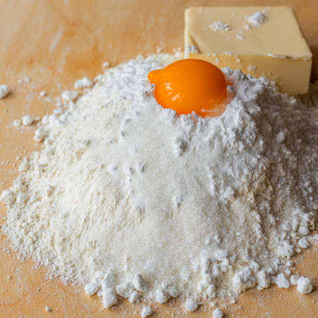 Products for dough, flour, sugar and eggs on the board. Homemade pastries. Shortbread. Butter cookiesの写真素材