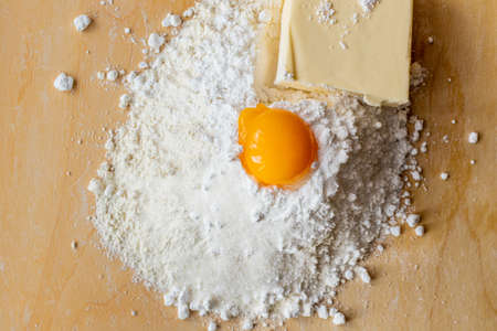 Products for dough, flour, sugar and eggs on the board. Homemade pastries. Shortbread. Butter cookiesの写真素材