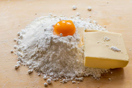 Products for dough, flour, sugar and eggs on the board. Homemade pastries. Shortbread. Butter cookiesの写真素材