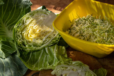 Sliced cabbage for salad. White cabbage leaves. Vegetables for dinner. Raw treats. Rural table preparation for dinner.の写真素材
