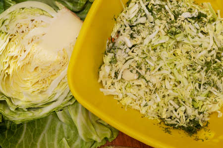 Sliced cabbage for salad. White cabbage leaves. Vegetables for dinner. Raw treats. Rural table preparation for dinner.の写真素材