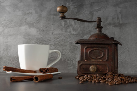 White cup, cinnamon and coffee beans on a gray background. Morning coffee. Coffee shop menu.の写真素材