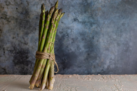 Green asparagus in a bunch. Vegetable season. May delicacies. healthy food. Vegan delicacies. dark background.の写真素材