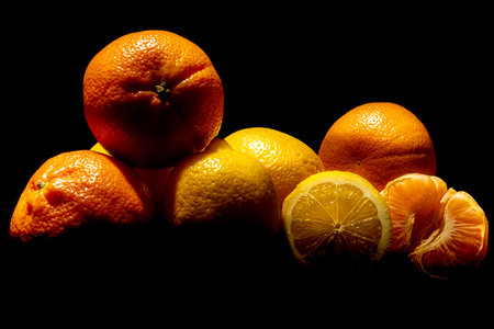Lemons and mandarins on a black background. Healthy fruits. Detox. Citrus in the kitchen. Body cleansing.の写真素材