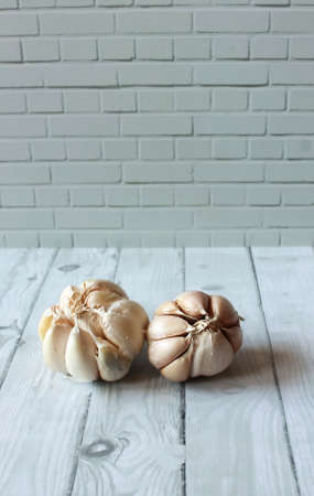 Photo of Two Garlic on a wooden patterned tableの写真素材