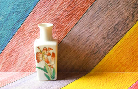 Photo of a small ceramic jar decoration on a colorful abstract backgroundの写真素材