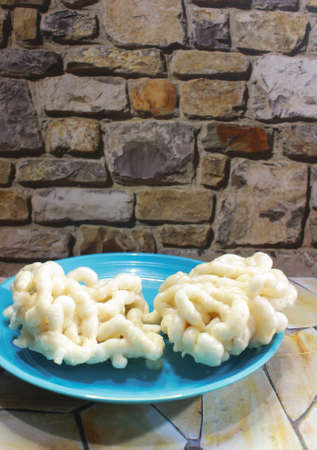 Photo of two fish crackers in a blue plate on a stone patterned tableの写真素材