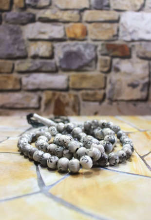 A photo of a prayer beads on a table with stone and cement patternsの写真素材