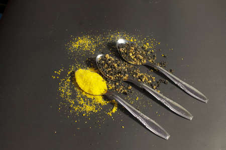 Photo of dried yam and corn powder in spoon on black backgroundの写真素材
