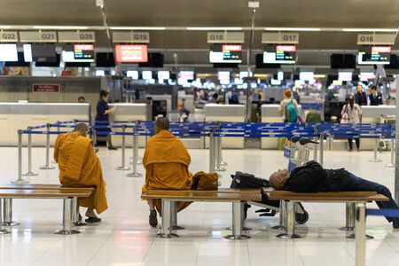 Bangkok, Thailand - march 1, 2016: Monks and businessman waiting fly in night quiet airport terminalのeditorial素材