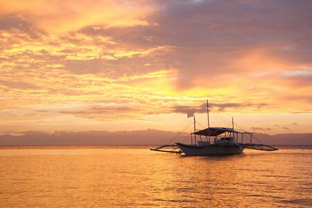 Amazing colorfull sunset at the sea with philippine boat in Moalboal. Philippines