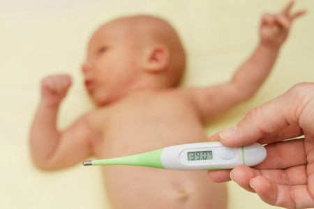 thermometer with high temperature and sick newborn babyの写真素材
