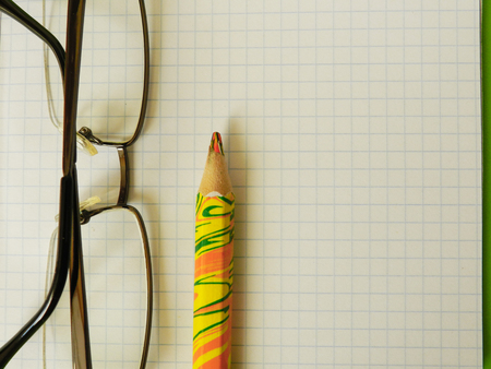Notebook color pencil and part of glassesの写真素材