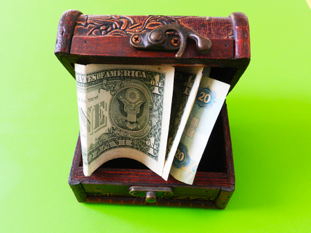 Open chest with money on the green backgroundの写真素材