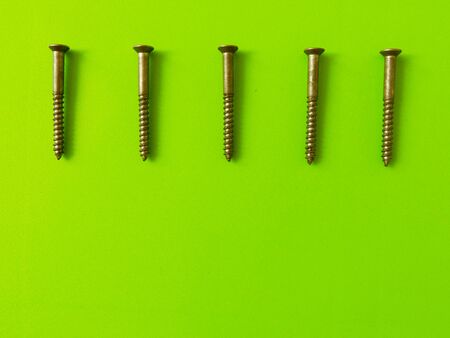 Five same screws on the green backgroundの写真素材