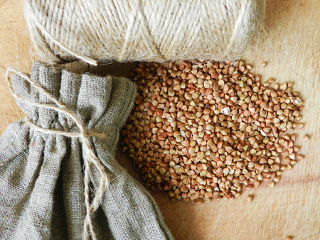 Buckwheat near sac and twine knot on the table close up photoの写真素材