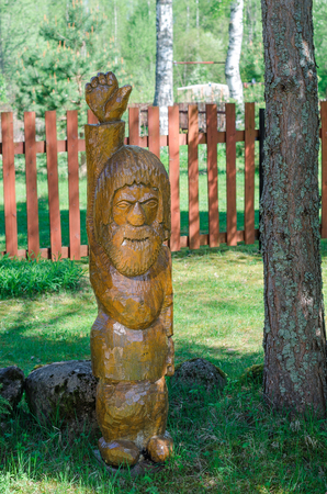 Statue made of pine. Wooden man. Option of your garden decorの写真素材
