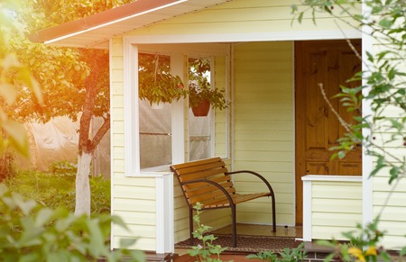 Entrance porch decorated with antique bench, big flower pots with flowers. Russiaの写真素材
