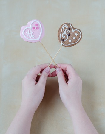 Womans hands holding a Valentine cookiesの写真素材
