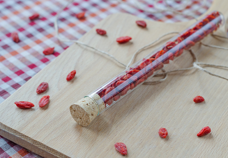 Goji berries in a glass vessel on a wooden Board. Closeupの写真素材