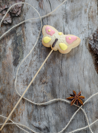 Cookies on a stick in the form of a butterfly on aged woodの写真素材
