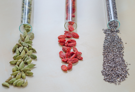 Chia seeds, Goji berries and green cardamom in glass bulbsの写真素材