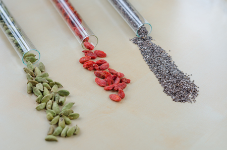 Chia seeds, Goji berries and green cardamom in glass bulbsの写真素材