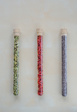 Chia seeds, Goji berries and green cardamom in glass bulbsの写真素材