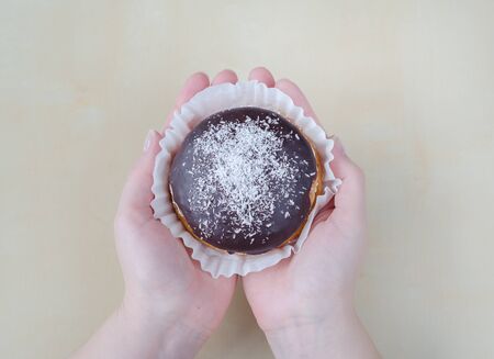 Cake with chocolate and coconut on woman hands. Closeupの写真素材