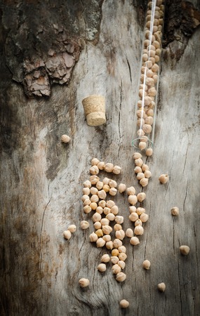 Chickpeas in a glass flask on aged wood. Closeupの写真素材