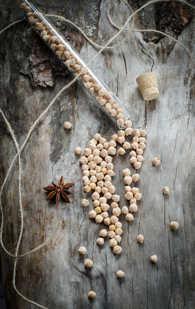 Chickpeas in a glass flask on aged wood. Closeupの写真素材