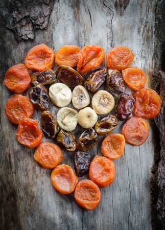 Assortment of dried figs, dates and apricots in the form of heart. Closeupの写真素材