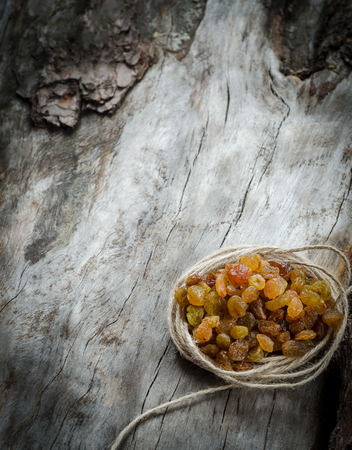 Raisins with distressed twine on wood. Closeupの写真素材