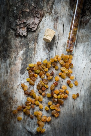 Raisins in a glass flask on aged wood. Closeupの写真素材
