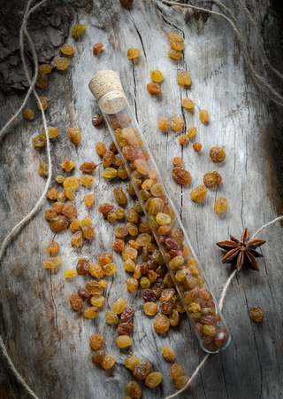 Raisins in a glass flask on aged wood. Closeupの写真素材