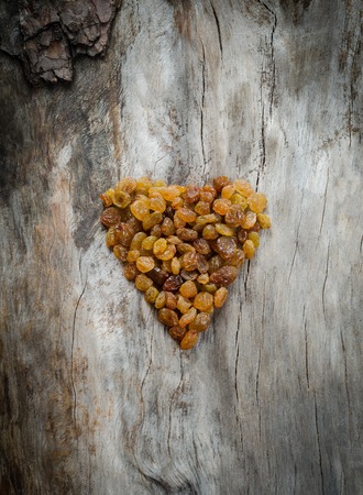 Yellow raisins in the form of heartの写真素材