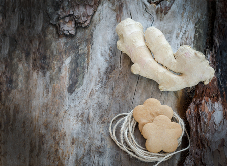 Ginger root and ginger biscuits on aged woodの写真素材