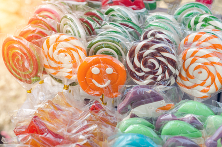 Great choice of colorful caramel on stick candy for sale in shop window.の写真素材