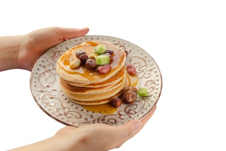 Stack of hot pancakes in woman hands. Isolated.の写真素材