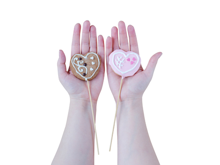 Woman's hands holding a Valentine cookies isolated on white background.の写真素材