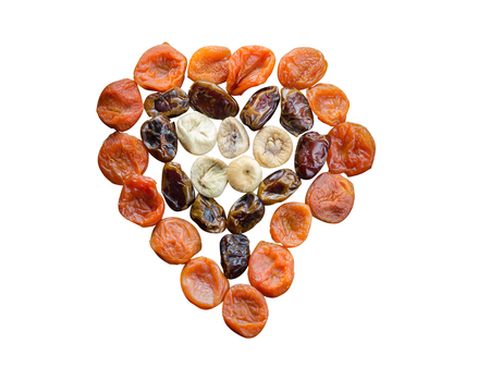 Assortment of dried figs, dates and apricots in the form of heart isolated on white background.の写真素材