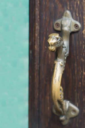 Old brass handle on vintage wood door in form of panther.の写真素材