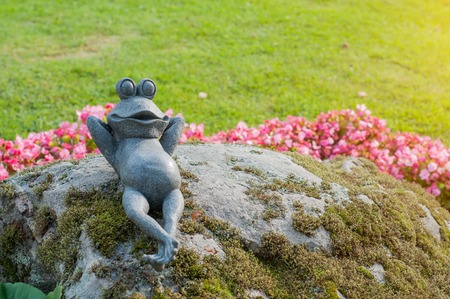 Decorative frog in the garden.ceramic green frog figurine, frog sitting on the stonesの写真素材