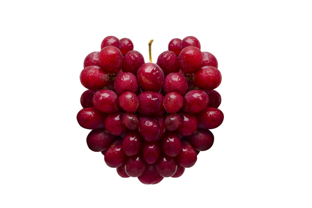 Fresh red grapes in the form of heart isolated on white background.の写真素材