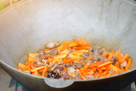 Cooking meat outdoors in cast-iron cauldronの写真素材