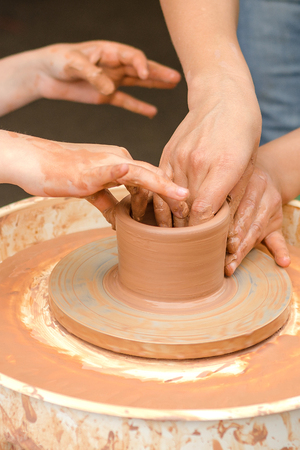 A close-up of the child learns to knead the clay.の写真素材