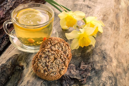 Homemade oatmeal cookies with a cup of tea on old wooden background.の写真素材